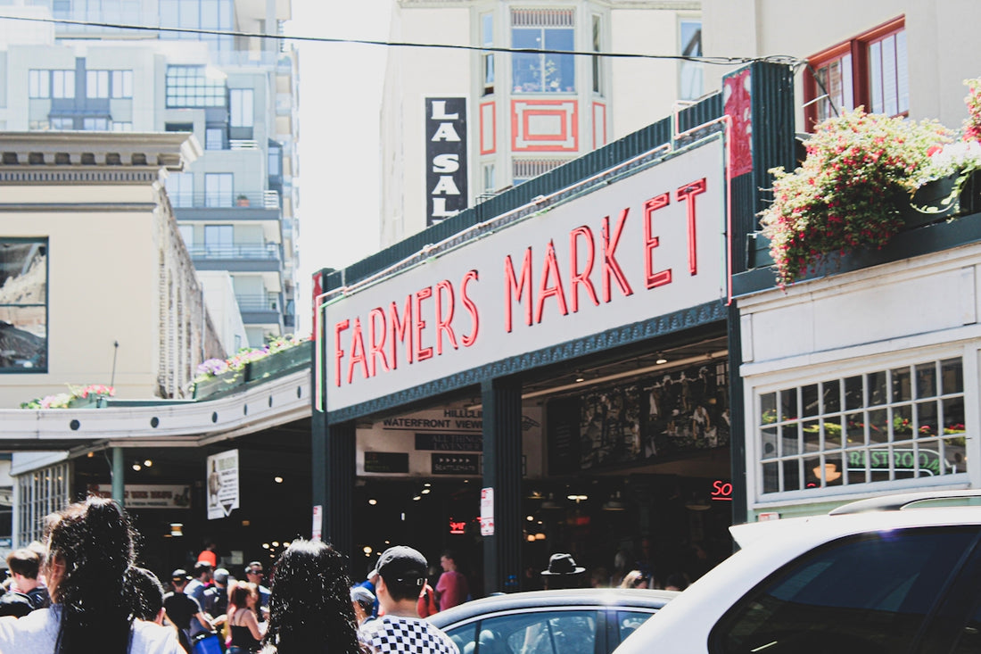 crowd walking on side walk near Farmer's Market during daytime