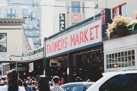 crowd walking on side walk near Farmer's Market during daytime