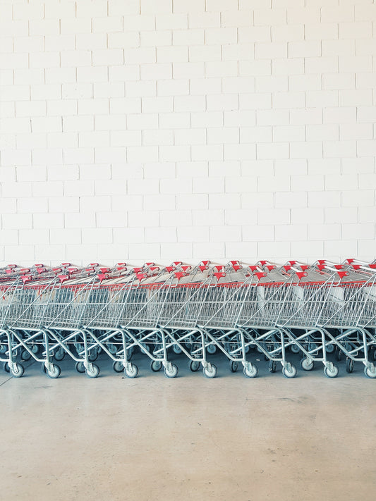 gray-and-red metal shopping cart lot beside wall