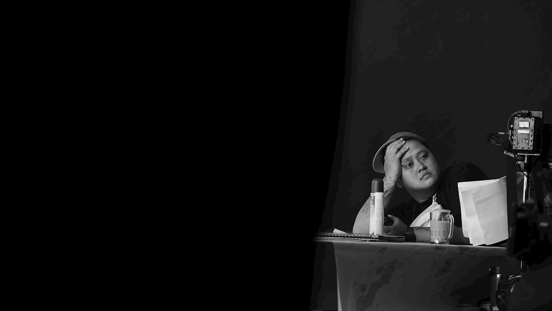 a black and white photo of a woman sitting at a table