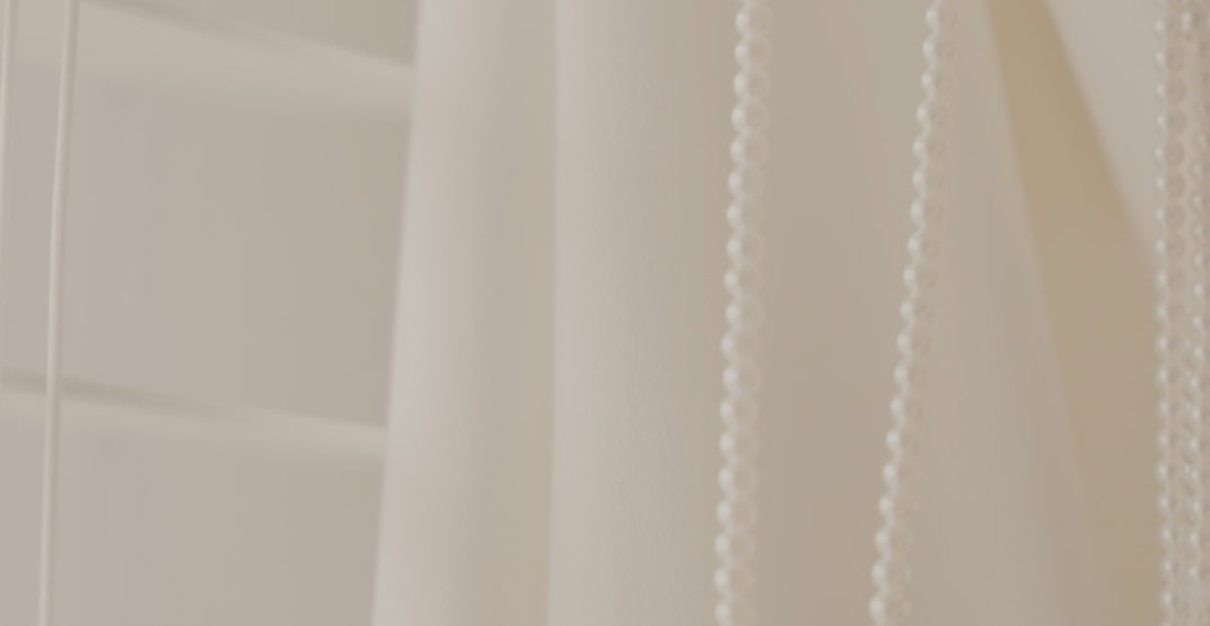 a close up of a white curtain with beads hanging from it