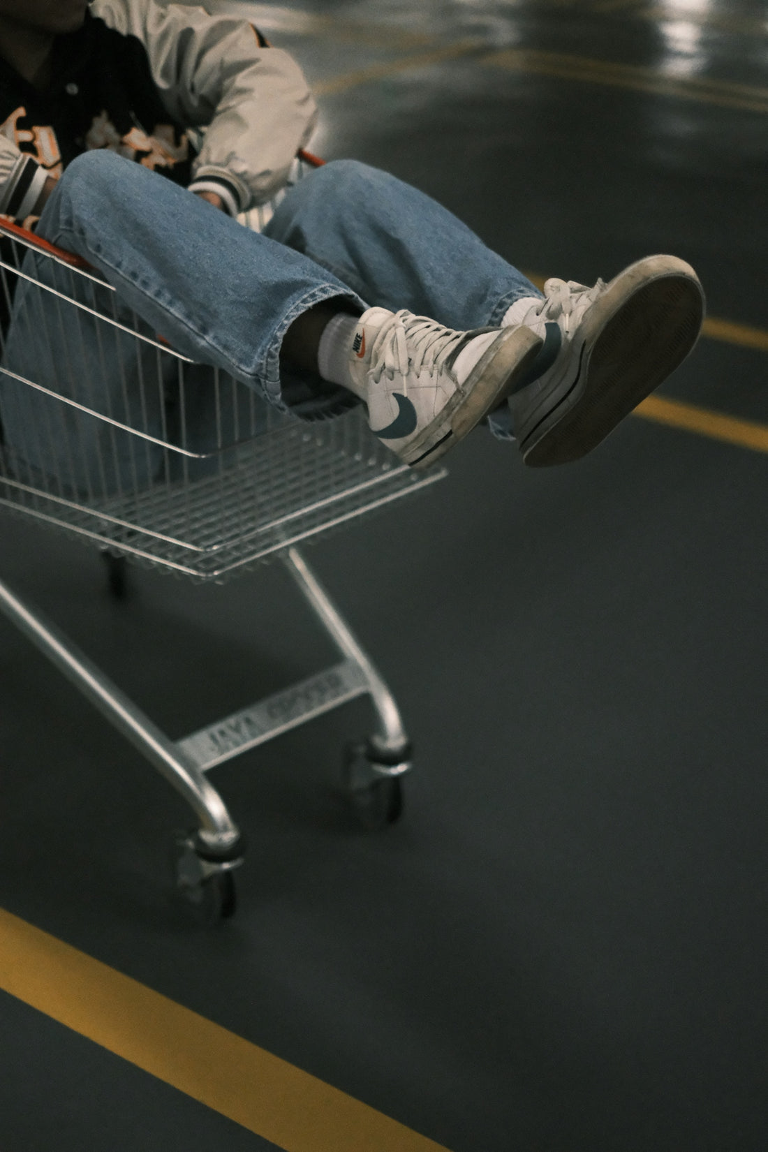 a man laying on top of a shopping cart