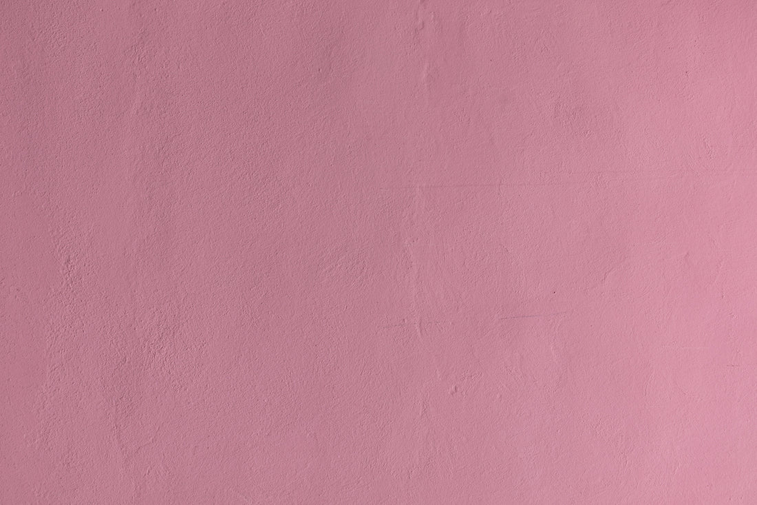 a pink wall with a clock on it