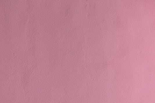 a pink wall with a clock on it