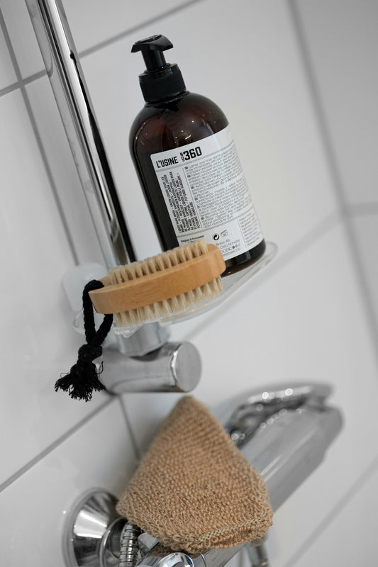 A bottle of soap sitting on top of a faucet