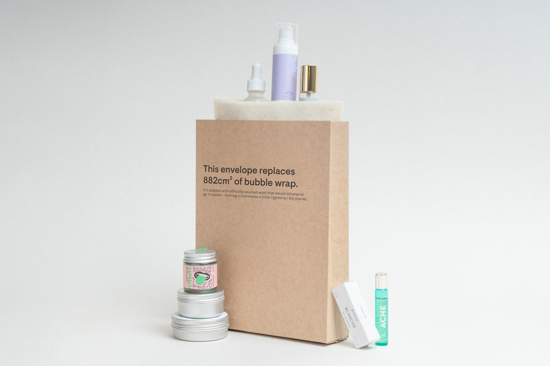 Cosmetic products arranged around a cardboard packaging.