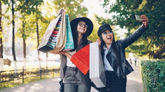 Two women taking a selfie with shopping bags